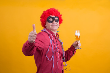 man with wig and streamers drinking funny and doing ok symbol, party concept
