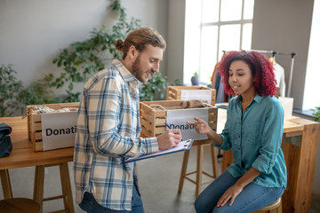 Young man and girl communicate in the process of work.