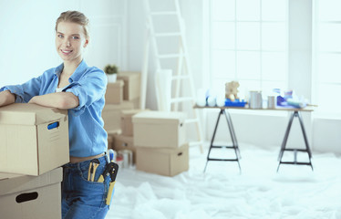 Young woman moving house to new home holding cardboard boxes