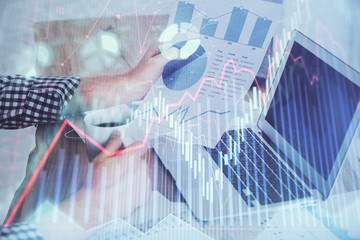 Double exposure of forex chart with man working on computer on background. Concept of market analysis.