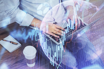 Forex graph with businessman working on computer in office on background. Concept of analysis. Double exposure.