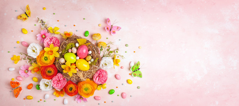 Creative Holiday Concept With Easter Eggs In Nest, Spring Flowers And Candy