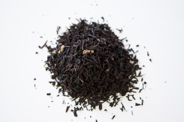 Black tea with additives close-up on a white background. A handful of tea for brew.