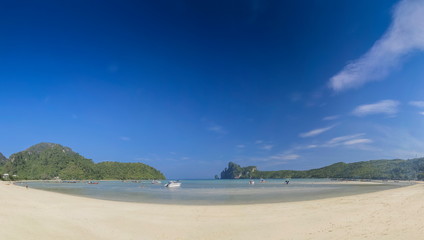view seaside panorama on white sand beach with blue-green sea, mountains and blue sky background, Loh Dalum Bay, Phi Phi Don island, Krabi, southern of Thailand.