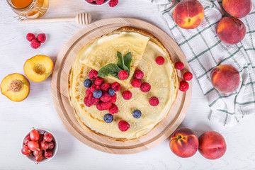 Crepes with jam, berries and sugar powder. Homemade pancakes, delicious breakfast, Russian pancakes