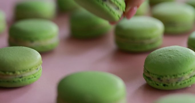Female hand take a one green macaroon from big macaron collection