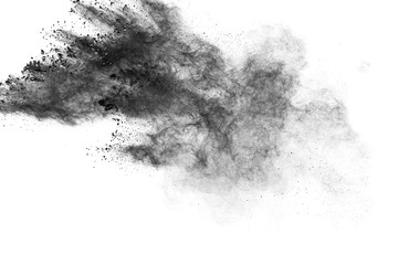 Black powder explosion against white background.Charcoal dust particles cloud.