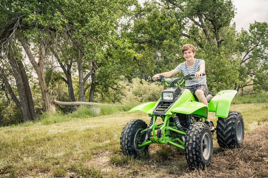 Young boy riding an atv at a picnic in a park. Bridger, Montana, USA