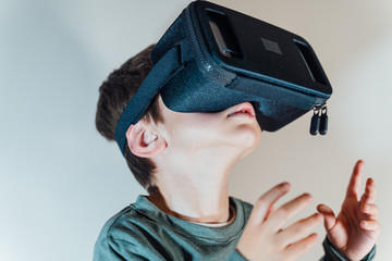 Child using new Virtual Reality, VR cardboard glasses