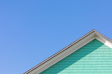 Peppermint green tiled wall, rooftop and blue sky minimal composition with copyspace