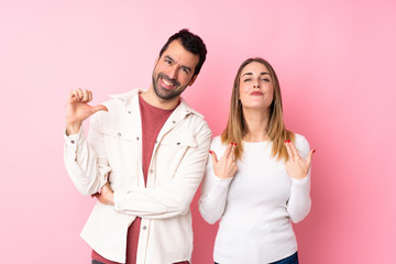 Couple in Valentine Day over isolated pink background proud and self-satisfied in love yourself concept