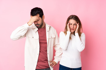 Couple in Valentine Day over isolated pink background unhappy and frustrated with something