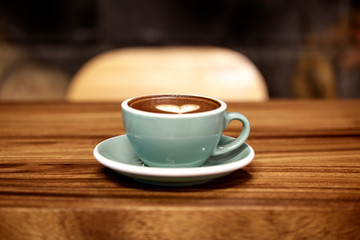 Mug of latte art coffee on wooden
