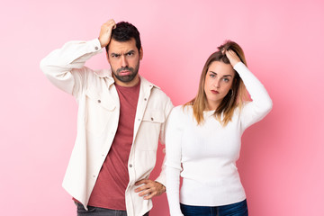 Couple in Valentine Day over isolated pink background with an expression of frustration and not understanding