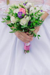 Young happy bride with a wedding bouquet by a bouquet.