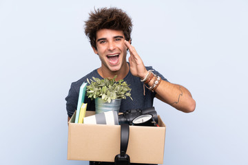 Man making a move while picking up a box full of things shouting with mouth wide open