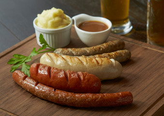 Mix German sausage in various size serve with mash and pepper sauces.