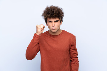 Young caucasian man over isolated blue background with angry gesture