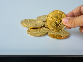 The fingers are picking up the gold bitcoin.