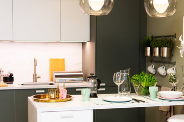 Modern table with utensils and vegetables over kitchen background.