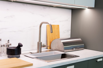 Water tap and sink in a modern kitchen design.