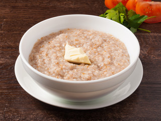 wheat porridge with a piece of butter in a white plate