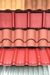 Various types of roof coverings in the window of a construction store.