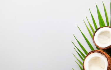 Coconut and pieces of coconut on gray background, top view, copy space