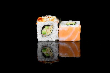 roll with salmon on a black background with insulation and reflection