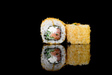 tempura roll with salmon on a black background with insulation and reflection