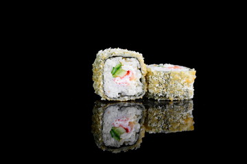 tempura roll with salmon on a black background with insulation and reflection