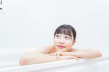 お風呂でお湯に浸かる若い女性