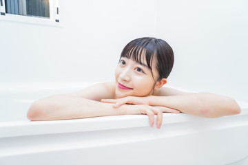 お風呂でお湯に浸かる若い女性