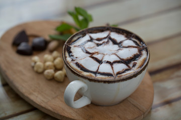 cup of coffee and nuts on wood table