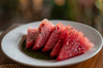 Juicy yummy Organic watermelon pieces in a decorative serving with mint leaves under sunlight during the touristic relaxation in the morning breakfast