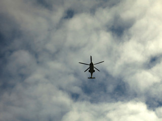 flying helicopter against the sky above the trees