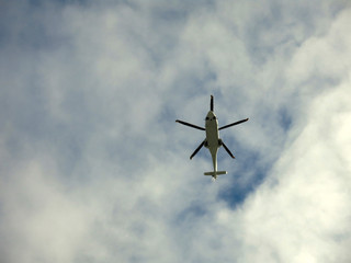 flying helicopter against the sky above the trees