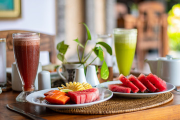 Delicious Organic watermelon, papaya, pineapple pieces in a decorative serving with watermelon and ginger lemon juice glass during the morning breakfast