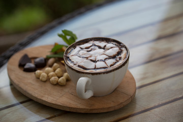 cup of coffee and nuts on wood table