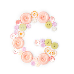 Letter G from pink and green buttons isolated on white background. Sewing kit. Colorful buttons, stylish alphabet for handmaking hobby. Handmade sew abc. Text from buttons