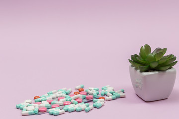 Various pills, capsules and tablets in blisters on a pink background