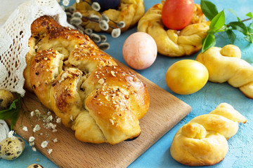 Traditional Italian Easter bread rings. Easter sweet bread with colored eggs on a blue stone concrete tabletop.