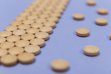 Many brown pills on a purple background
