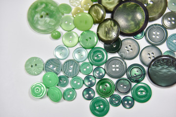 Green buttons of different shape and size on the white background. Selective focus.