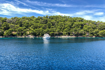 Fototapeta na wymiar Luxury motoryacht moored in wonderful bay with turquoise water