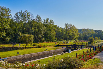 Fototapeta premium Image of a lock on the Canal d'ille du Rance, Brittany, France early morning, with clear blue sky.