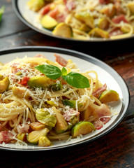 Homemade Brussels sprouts, bacon, pancetta pasta with parmesan cheese. On wooden table