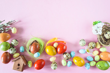 Festive easter holiday background. Various easter eggs, bird house, nest on pink background. Space for text, flat lay