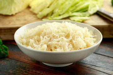 Fresh pickled cabbage in white bowl on wooden table. healthy food