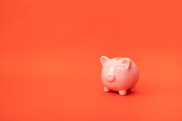 Minimal business metaphor concept of piggy bank on a red background